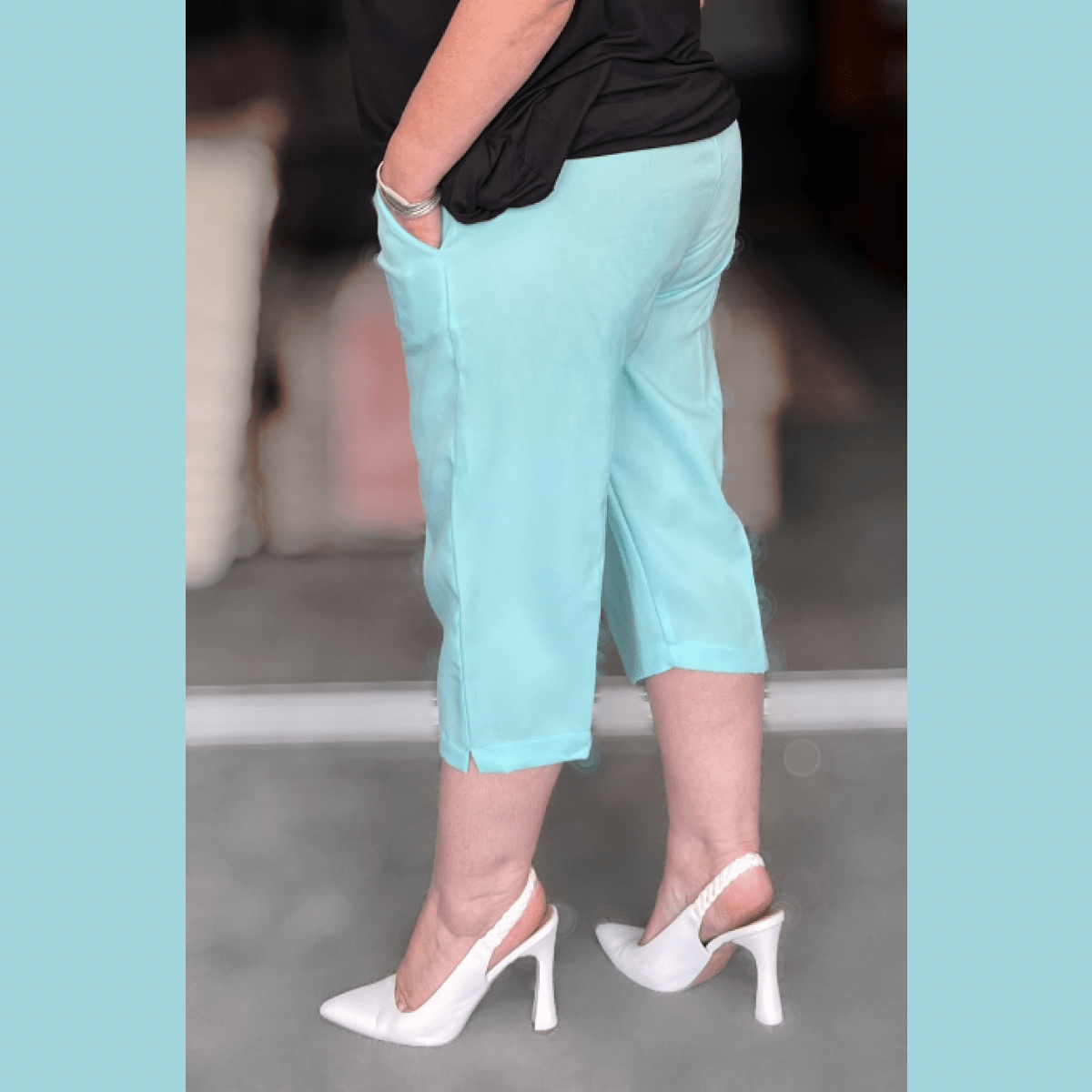 Aqua Capris featuring side pockets, paired with stylish white heels.