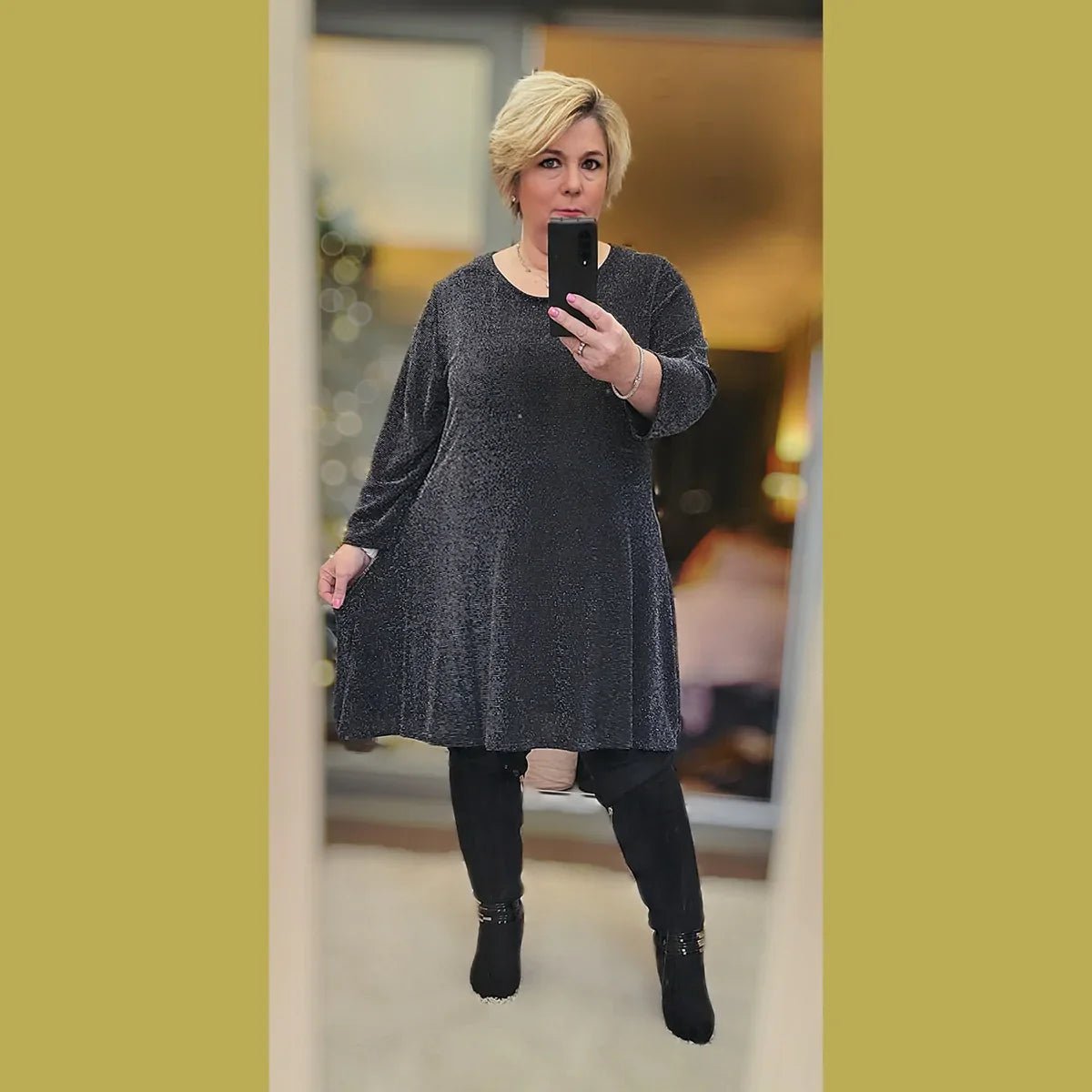 Black Sparkle Tunic Dress featuring a relaxed fit and long sleeves, styled with black leggings.