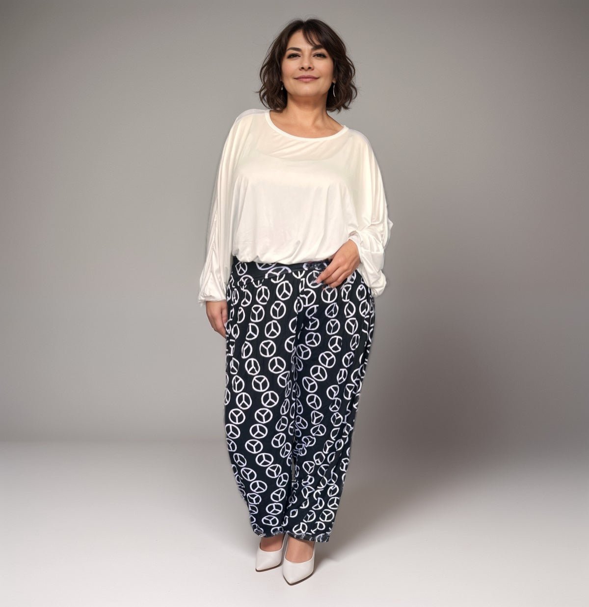 Comfortable plus-size outfit featuring a white top and patterned black pants.