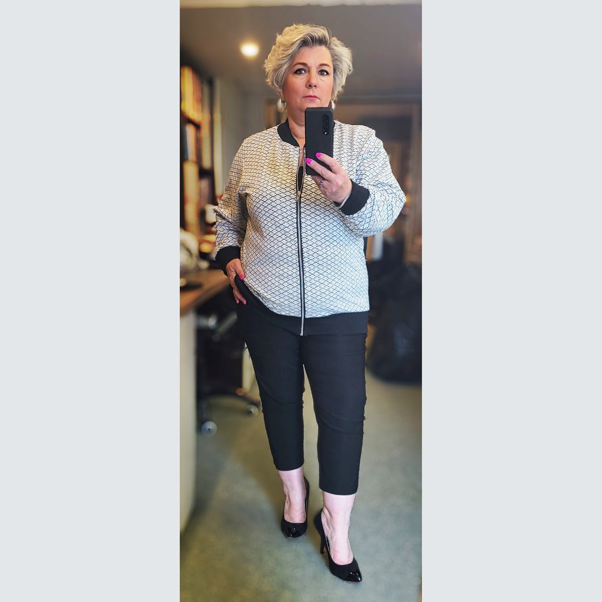 Stylish bomber jacket featuring a textured design, paired with black pants and heels.