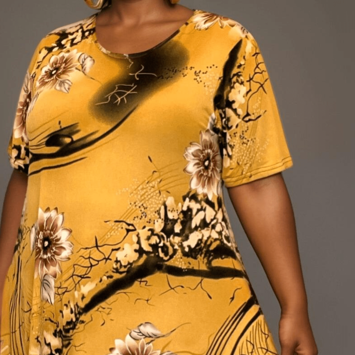 Yellow floral print tunic featuring a relaxed fit and short sleeves.